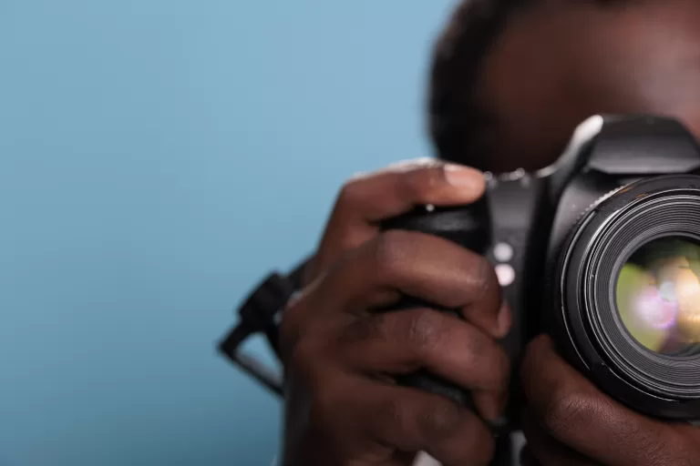 male photographer taking photo with professional DSLR camera